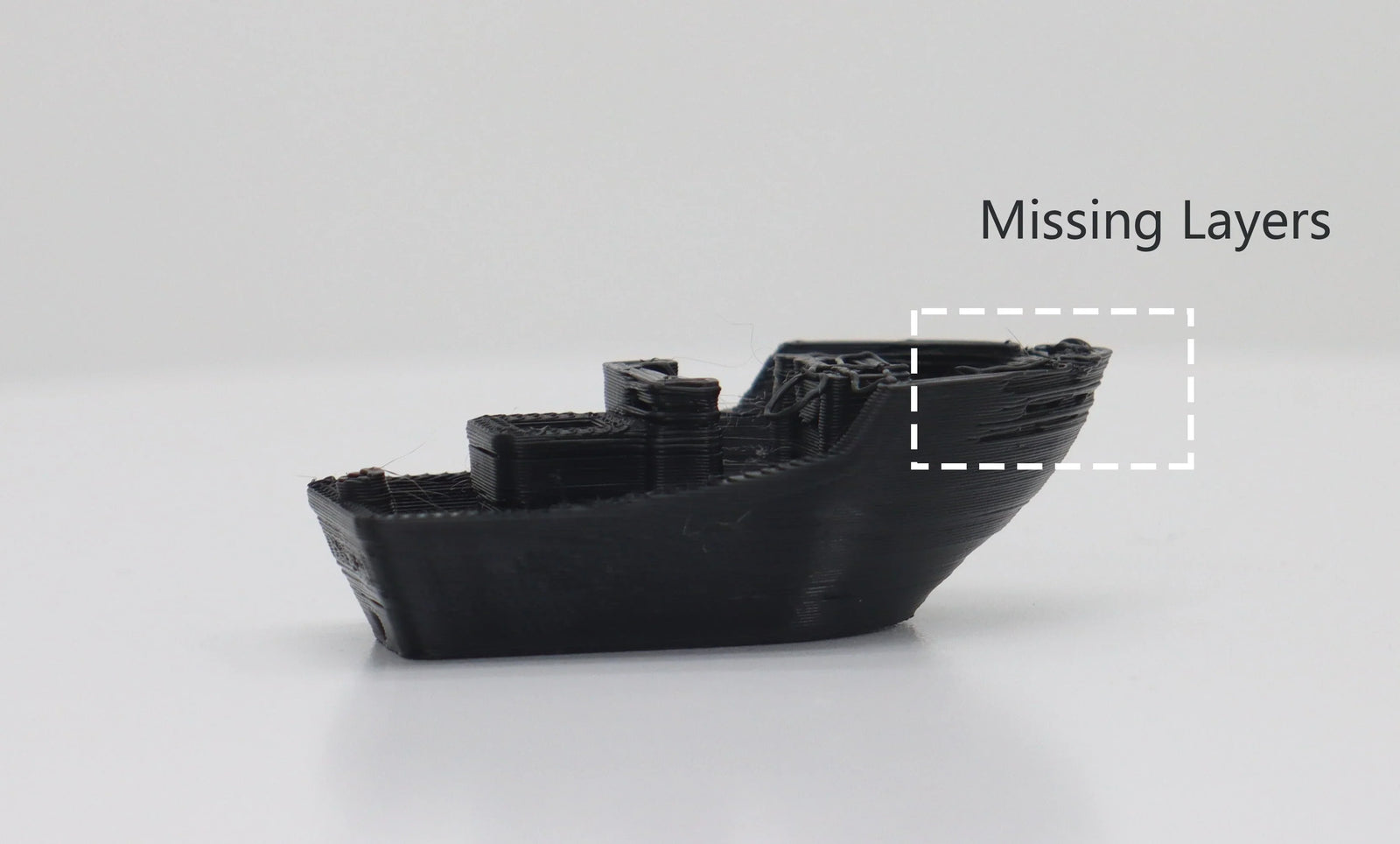 黒い 3D Benchy モデル。ハイライト表示されたボックスは船体の欠落したレイヤーを示し、押し出し不足の印刷欠陥を示しています。